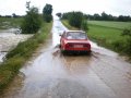 Přívalové deště v červenci 2009 - proudy vody přalévající se přes silnici od Nových Dvorů k Suchdolu